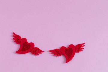 Wall Mural - Red felted hearts on pink background, St Valentines Day postcard