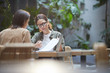 © Seventyfour - Portrait of two female entrepreneurs discussing project while working at table in outdoor cafe terrace, copy space