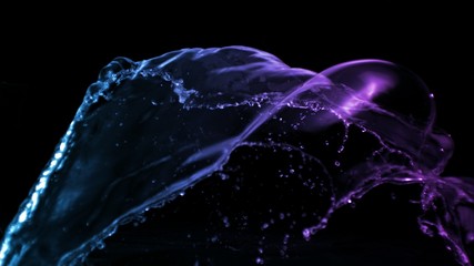 colourful isolated liquid water splash in purple and blue light on black background forming a beautiful floating silhouette of water