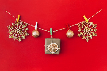 Wall Mural - Christmas handmade garland made of golden snowflakes and other christmas decorations on red background.