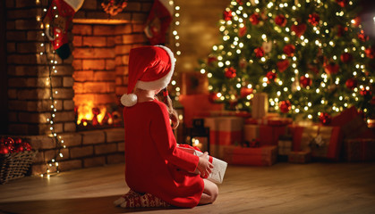 Wall Mural - happy laughing child girl with magic gift on christmas eve.