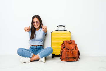 Wall Mural - Young mixed race indian woman ready to go to travel cheerful smiles pointing to front.