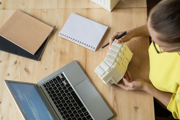 Canvas Print - Top view of female architect describing characteristics of new residence model