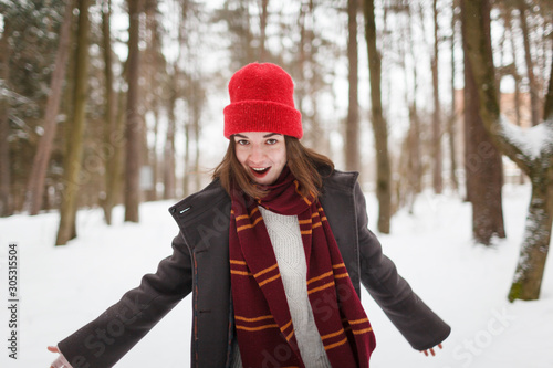 Cuadros en Lienzo Young woman with brown hair and gryffindor scarf is dancing in winter forest