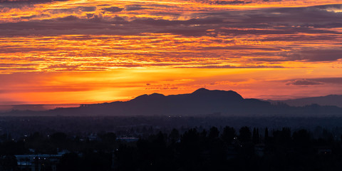 Wall Mural - Los Angeles panoramic dawn with colorful fall clouds.  San Fernando Valley view towards Griffith Park and the Santa Monica Mountains from the Santa Susana Pass in Chatworth, California. 