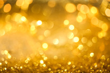Abstract Bokeh Of Glowing Yellow Lights And Sparkling Gold Glitter Background Or Wallpaper