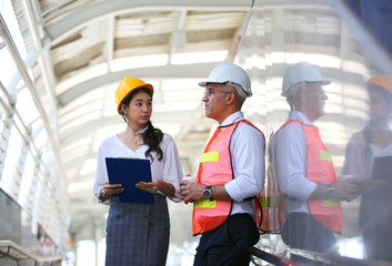 Portrait of multiethnic architect with blueprints and business industrial man engineer at construction building