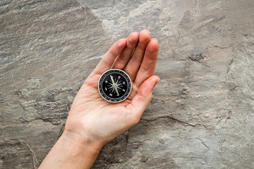 Wall Mural - Choose direction concept. Compass in hand on grey background top view copy space