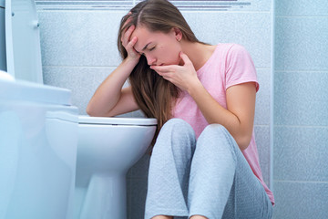 Wall Mural - Young woman suffers from nausea and vomiting due to digestive and stomach illness problems. Morning toxicosis in first trimester of pregnancy.