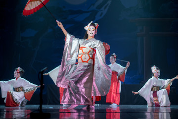 Wall Mural - Traditional Japanese performance. Actresses in traditional white and red kimono and fox masks dancing with umbrella and fans.