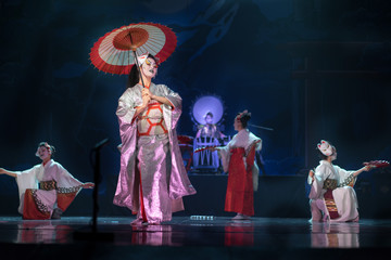 Wall Mural - Traditional Japanese performance. Actresses in traditional white and red kimono and fox masks dancing with umbrella and fans.