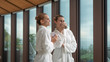 © Kitreel - Two young women in white bathrobes are drinking a hot tea after various treatments in a relax room of a luxury wellness center.