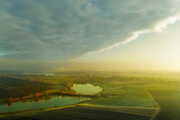 Naklejka na meble Fog is approaching the autumn meadow with the lake.
