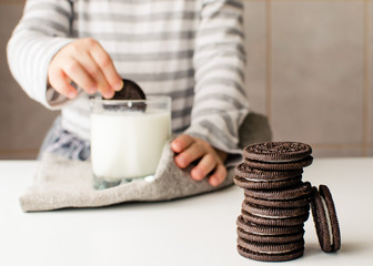 Oreo and kids hands with cookies and milk. Girl, milk and cookies