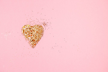 Golden glitter love heart on a pink background