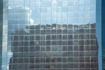 Close-up of office building facade with sky reflection