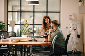 Wall Mural - Colleagues in office. Businesswoman and businessman discussing work in office. Two friends in working together.  