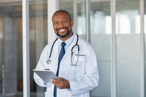 Obraz Dibond Portrait of happy african doctor at private clinic