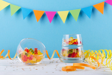 Wall Mural - jelly candy in glass bowl on blue party background