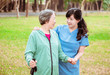 © Tom Wang - Smiling nurse helping senior woman to walk around the park