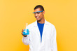 © luismolinero - Scientific man holding a laboratory flask over isolated background with happy expression