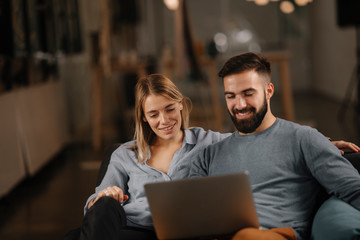 Poster - Young happy couple. Partners using laptop tohether. 