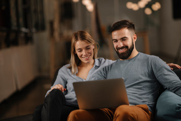 Wall Mural - Young happy couple. Partners using laptop tohether. 