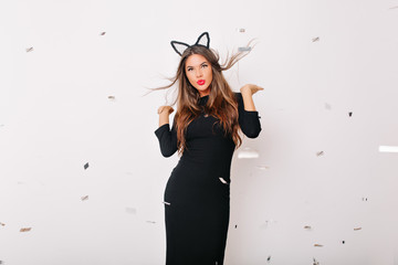 Wall Mural - Jocund caucasian woman in long dress looking to camera with interest. Studio shot of enchanting long-haired girl isolated on white background.