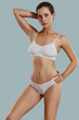 © nazarovsergey - Young woman in white underwear, with bundled hair, posing in studio against gray background. Plastic surgery, aesthetic cosmetology. Close-up.
