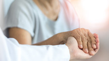 Elderly Female Hand Holding Hand Of Young Caregiver At Nursing Home.Geriatric Doctor Or Geriatrician Concept. Doctor Physician Hand On Happy Elderly Senior Patient To Comfort In Hospital Examination