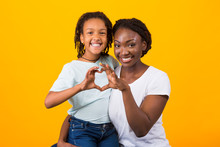 Smiling Afro Woman And Girl Making Heart Shape Sign
