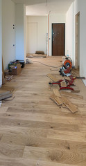 Wall Mural - Renovation of a room with laying out parquet , repair, building and home concept. Oak planks and white walls