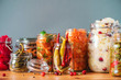 Assortment of various fermented and marinated food over wooden background, copy space. Fermented vegetables, sauerkraut, pepper, garlic, beetroot, korean carrot, cucumber kimchi in glass jars.