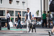 © Halfpoint - Young blind man with white cane and guide dog walking on pavement in city.