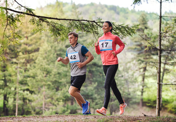 Poster - Young couple running a race competition in nature.