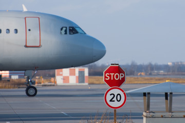 Stop sign on the road service vehicles on the platform of the airport, the aircraft's nose.