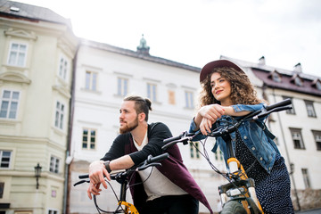 Wall Mural - young tourist couple travellers with electric scooters in small town.