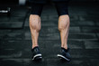 © ruslanshug - trained legs with muscular calves in sneakers in training gym during hard fitness and crossfit workout