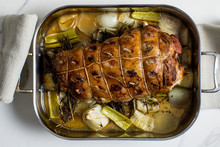 French Lamb Gigot With Herbs And Onions In Baking Pan