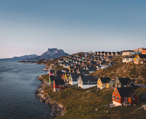 Wall Mural - Nuuk capital of Greenland with Beautiful small colorful houses in myggedalen during Sunset Sunrise Midnight Sun. Sermitsiaq Mountain in Background. Blue and pink Sky.