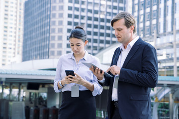 Leinwandbilder - Business man holds Laptop and discusses work with female  technician.They're Standing at a building site,Successful engineer or architect.
