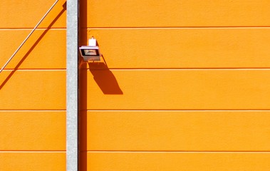 Canvas Print - Beautiful shot of an orange wall of a building with a video camera attached