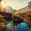 Wonderful Federa lake, natural Scenery, during Sunrise. Awesome Landscape. Foggy Dolomites Alps with forest under sunlight. Travel in nature. Beautiful sunrise with Lake and majestic Mountains.
