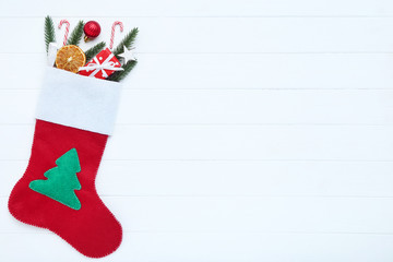 Wall Mural - Red stocking with christmas ornaments on white wooden table