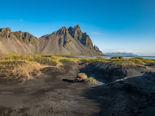 Epic view landscape of the black sand beach in Stokksnes on a sunny day. Vestrahorn mountain in the background. Nature and ecology concept background.