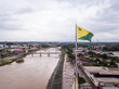Aerial drone view of Acre river and flag in the amazon. Rio Branco city center buildings, houses, streets, bridges on cloudy day. Brazil. Concept of environment, ecology, climate change and travel.