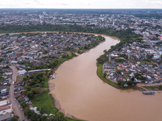 Wall Mural - Aerial drone view of Acre river curves in the amazon and Rio Branco city center buildings, streets on cloudy winter day. Concept of environment, ecology, global warming, climate change and travel.