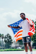 © Juan Miguel Aparicio/ADDICTIVE STOCK - Serious African American man holding American flag on shoulder and looking away