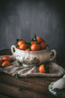 © Patricia Garcia/ADDICTIVE STOCK - Sophisticated still life with ripe orange tangerines with green leaves in deep white bowl on table on gray background
