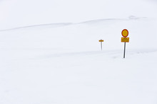 Red And Yellow Caution Signposts Located In Middle Of Snowy Nature On Cold Winter Day In Iceland